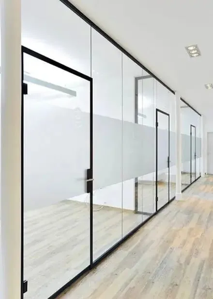 Cancel de cristal en oficinas con herrajes negros de diseño elegante.