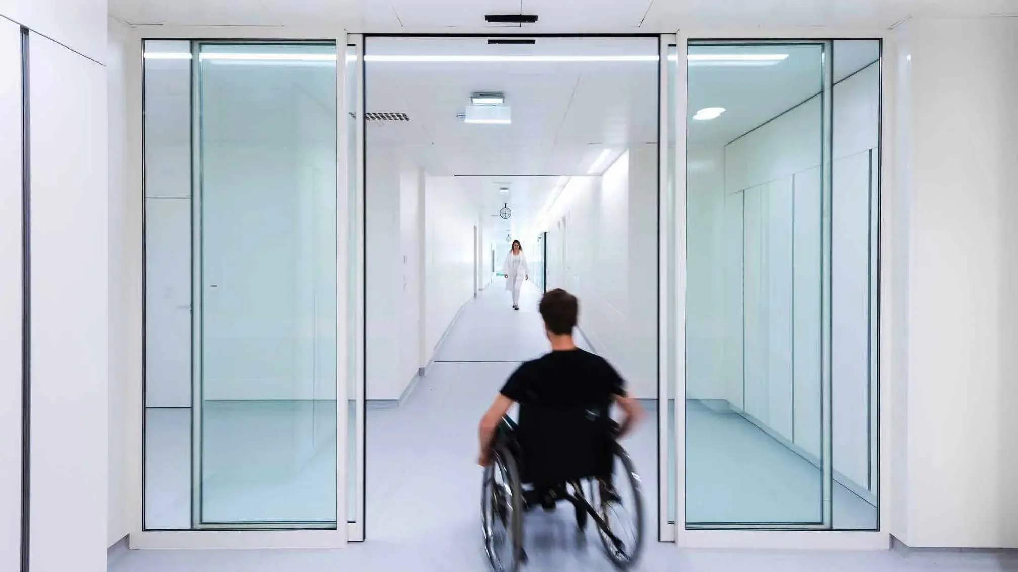 Puerta automática corrediza de cristal en pasillo de hospital.